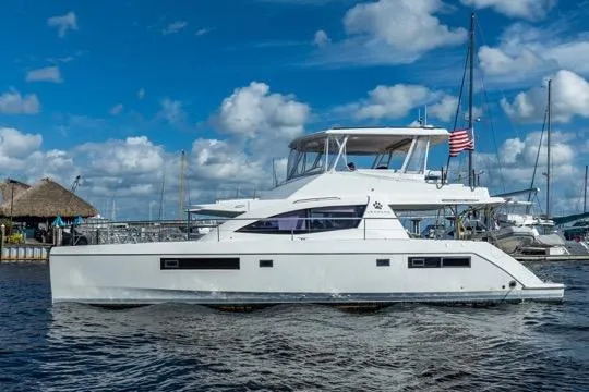 Slide: The Image of 2017 Leopard 51 Powercat yacht docked, featuring sleek design and American flag, under blue sky. - 147