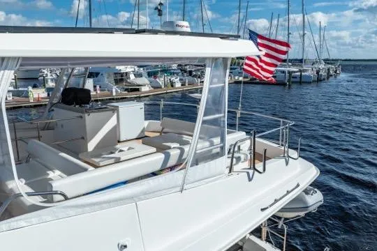 Slide: The Image of 2017 Leopard 51 Powercat yacht docked, featuring spacious deck and American flag. - 150