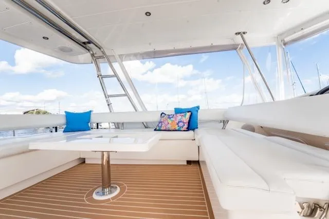 Slide: The Image of 2017 Leopard 51 Powercat interior with white seating, colorful cushions, and wooden flooring. - 20