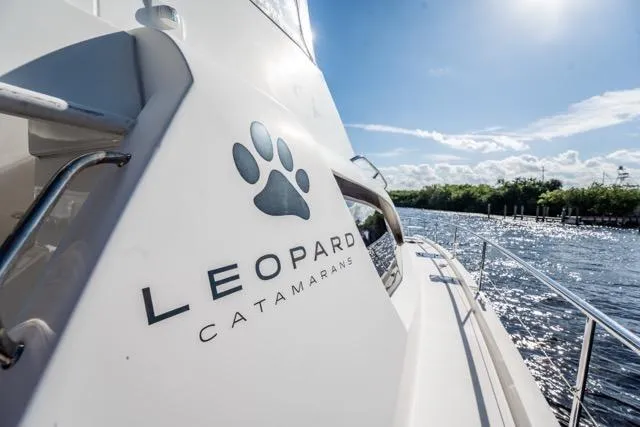 Slide: The Image of 2017 Leopard 51 Powercat catamaran cruising on a sunny day, featuring sleek design and branding. - 53
