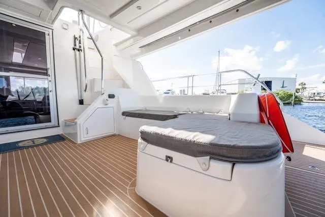 Slide: The Image of 2017 Leopard 51 Powercat yacht deck with seating, wooden flooring, and waterfront view. - 61