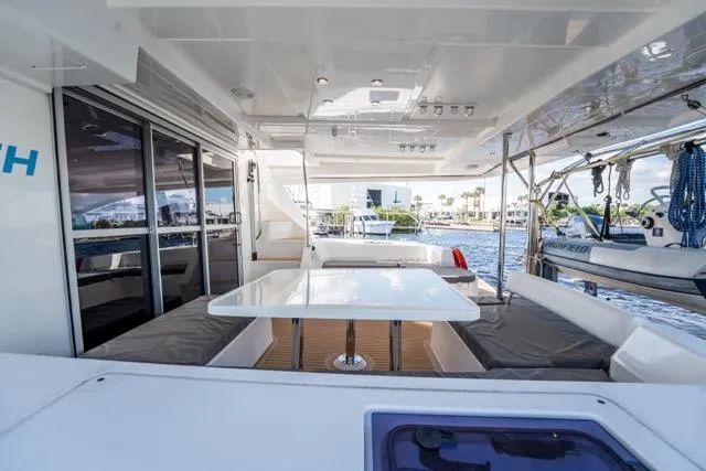 Slide: The Image of Spacious deck of 2017 Leopard 51 Powercat with seating and table, overlooking marina. - 62