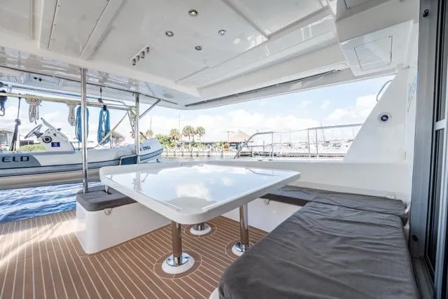 Slide: The Image of 2017 Leopard 51 Powercat yacht with outdoor seating and table, docked at marina. - 69