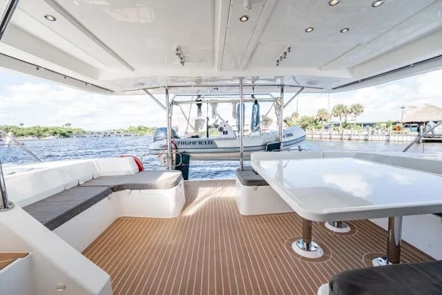 Slide: The Image of 2017 Leopard 51 Powercat yacht interior with spacious seating and table, overlooking serene waters. - 70