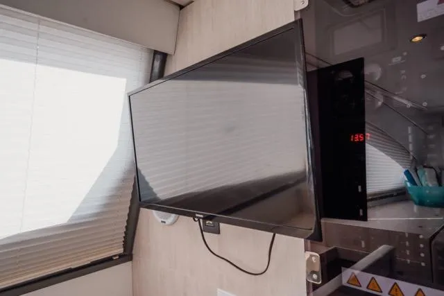 Slide: The Image of Wall-mounted TV in 2017 Leopard 51 Powercat interior, near window blinds. - 77