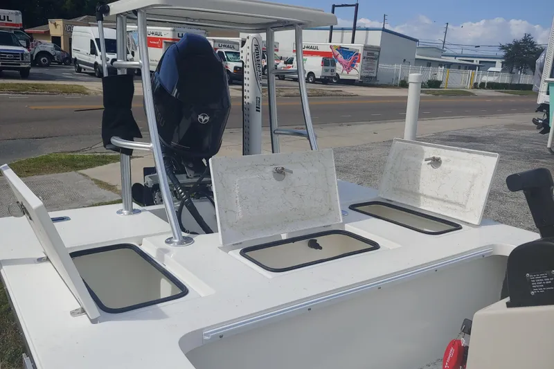 Slide: The Image of 2026 Mitzi Skiffs 17 Tournament boat with open storage compartments and outboard motor. - 5