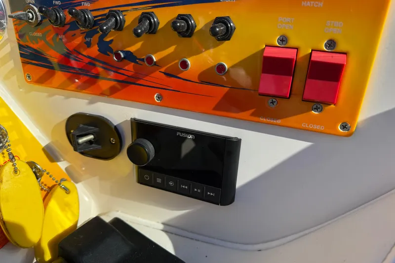 Slide: The Image of Control panel of a 2004 Fountain 42 Lightning boat with switches and a Fusion audio system. - 14