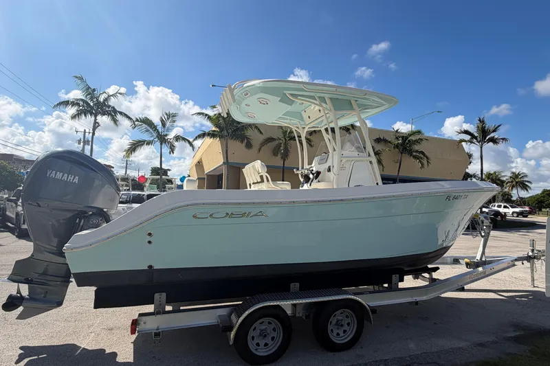 Slide: The Image of 2021 Cobia 237 Center Console boat on trailer, with Yamaha engine, parked outdoors. - 1