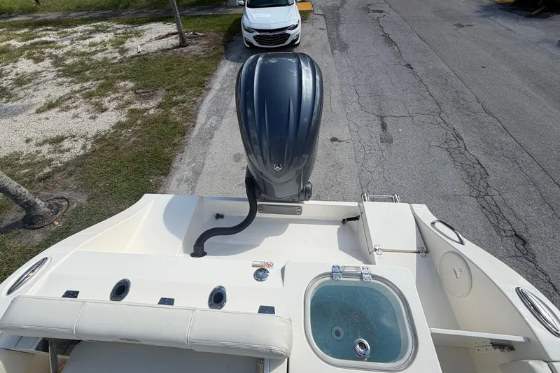 Slide: The Image of 2021 Cobia 237 Center Console boat with outboard motor and livewell, parked on a street. - 16