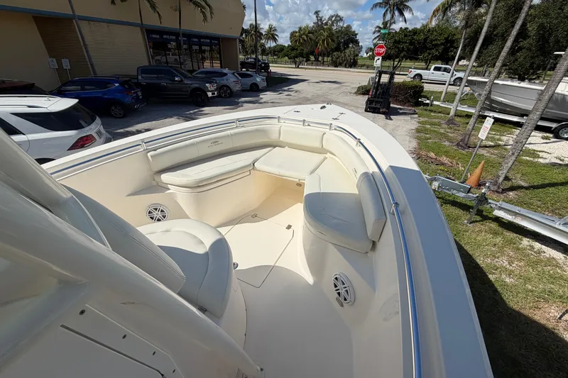 Slide: The Image of 2021 Cobia 237 Center Console boat with spacious seating, parked near palm trees. - 9
