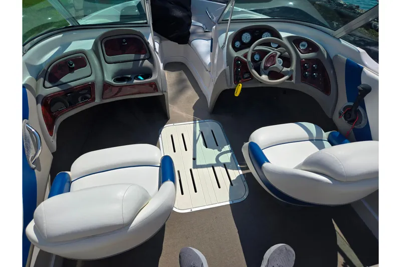 Slide: The Image of Interior of a 2003 Tahoe Q5L boat with white and blue seating, steering wheel, and dashboard. - 11