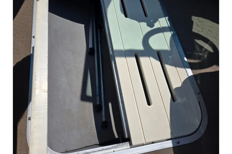 Slide: The Image of Open storage compartment in a 2003 Tahoe Q5L boat, showing interior details. - 12