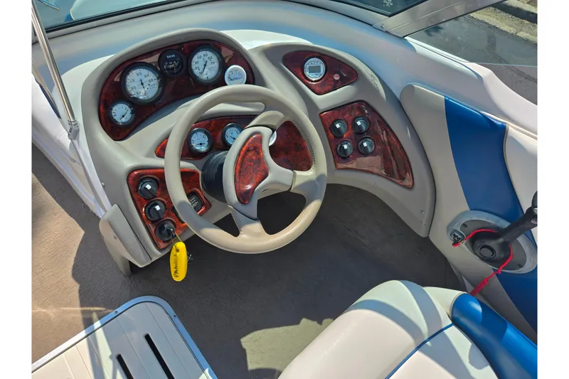 Slide: The Image of Steering console of a 2003 Tahoe Q5L boat with wood accents and gauges. - 15