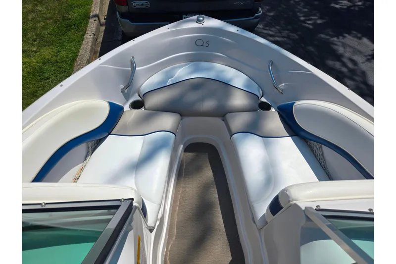 Slide: The Image of Bow seating area of a 2003 Tahoe Q5L boat with white and blue upholstery. - 17