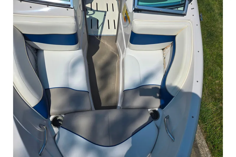 Slide: The Image of 2003 Tahoe Q5L boat interior with white and blue seating, cup holders, and open bow design. - 18