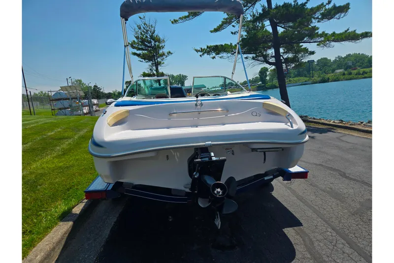 Slide: The Image of 2003 Tahoe Q5L boat on trailer by a lakeside, sunny day. - 2