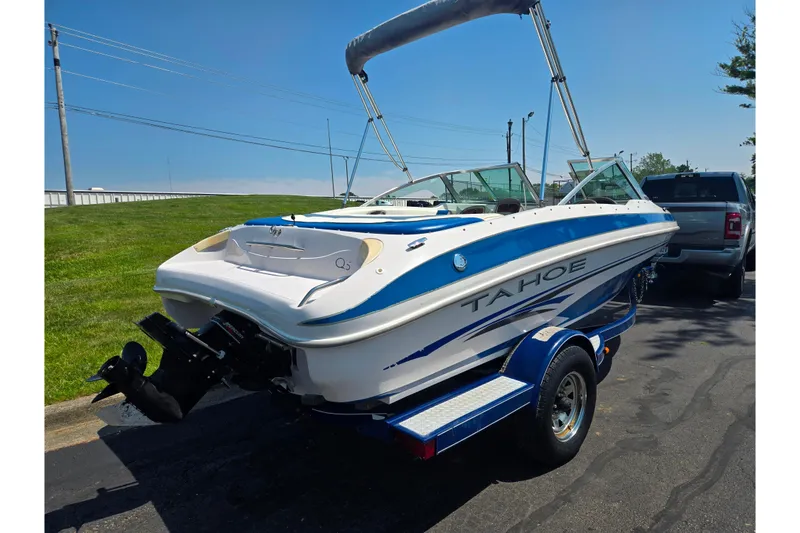 Slide: The Image of 2003 Tahoe Q5L boat on trailer, parked outdoors under clear blue sky. - 3