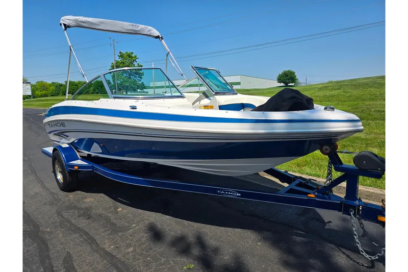 Slide: The Image of 2003 Tahoe Q5L boat on trailer, blue and white, parked outdoors. - 5