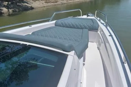 Slide: The Image of 2023 Axopar 37 XC CROSS CABIN boat with cushioned deck, docked on calm water. - 16