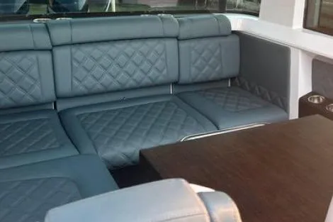 Slide: The Image of Luxurious interior of 2023 Axopar 37 XC CROSS CABIN with quilted seating and wooden table. - 27