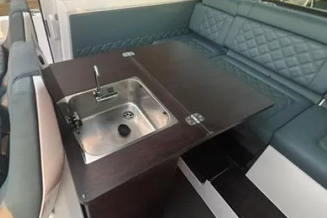 Slide: The Image of 2023 Axopar 37 XC CROSS CABIN interior with sink and seating area. - 28