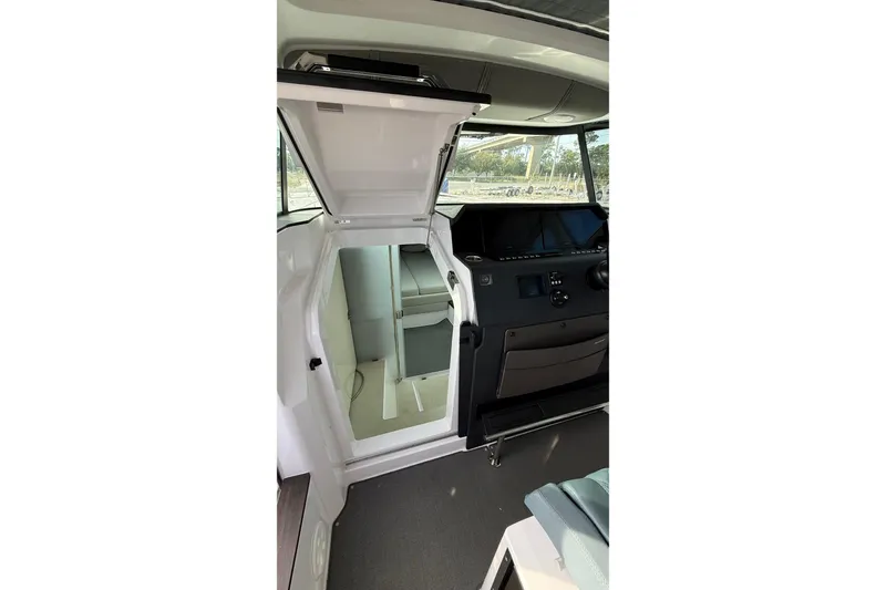 Slide: The Image of 2023 Axopar 37 XC CROSS CABIN interior with open door and control panel. - 29