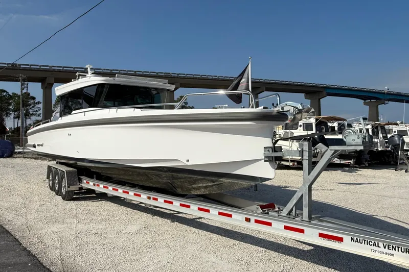 Slide: The Image of 2023 Axopar 37 XC CROSS CABIN boat on trailer, parked outdoors. - 3