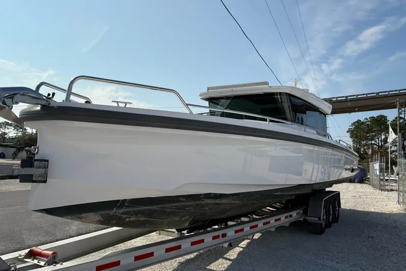 Slide: The Image of 2023 Axopar 37 XC CROSS CABIN boat on trailer under clear sky. - 4
