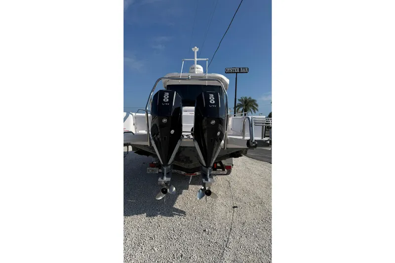 Slide: The Image of 2023 Axopar 37 XC CROSS CABIN with dual 300 V8 engines, parked on gravel. - 9