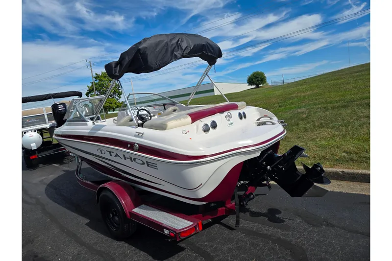 Slide: The Image of 2011 Tahoe Q4 SS boat on trailer, parked outdoors under a clear sky. - 3