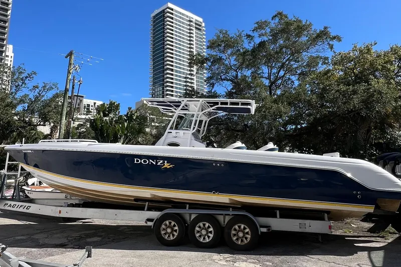The Image of 2008 Donzi 38 ZFX Open boat on trailer, urban backdrop, clear blue sky. - 0
