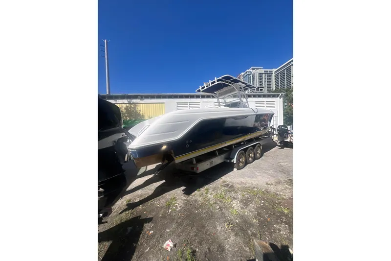Slide: The Image of 2008 Donzi 38 ZFX Open boat on trailer, parked outdoors under clear blue sky. - 2