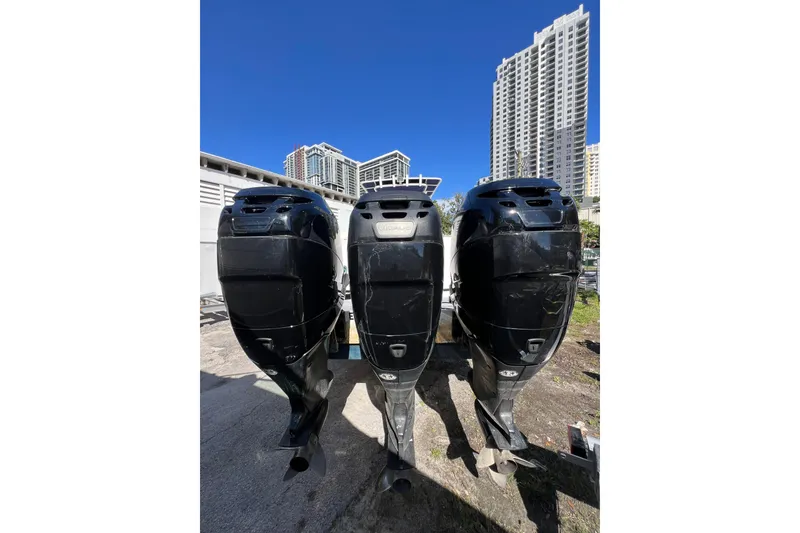 Slide: The Image of Three black outboard motors on a 2008 Donzi 38 ZFX Open boat, with cityscape background. - 3