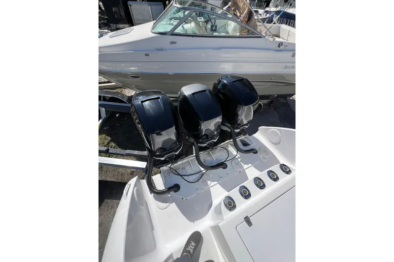 Slide: The Image of 2008 Donzi 38 ZFX Open with triple outboard engines, docked beside another boat. - 31