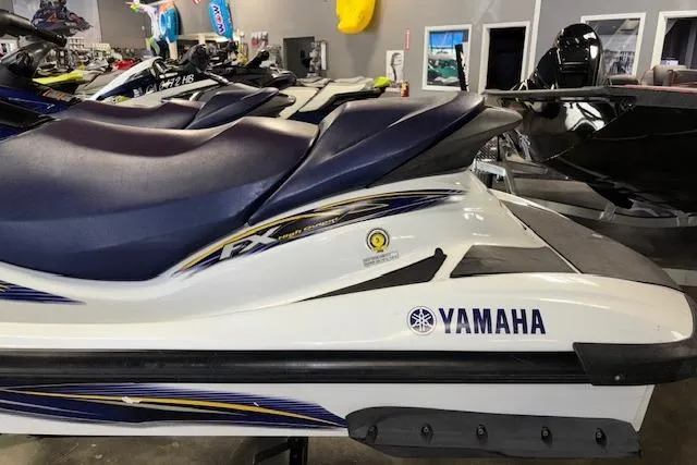 Slide: The Image of 2004 Yamaha WaveRunner FX jet ski with blue seat and white body in showroom. - 6