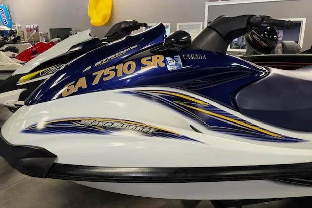 Slide: The Image of 2004 Yamaha WaveRunner FX jet ski with blue and white design in showroom. - 4