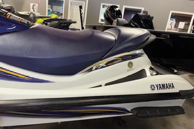 Slide: The Image of 2004 Yamaha WaveRunner FX jet ski with blue seat and white body in showroom. - 5