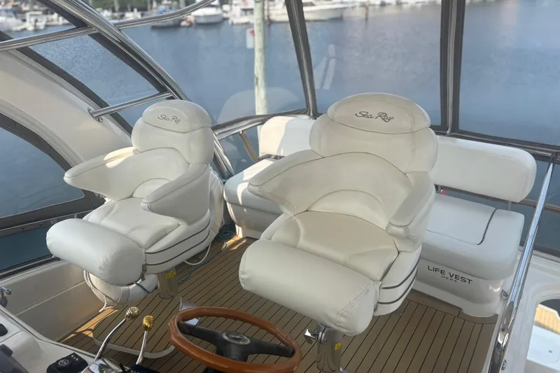 Slide: The Image of Luxurious helm seats on 2006 Sea Ray 52 Sedan Bridge yacht, overlooking marina. - 20