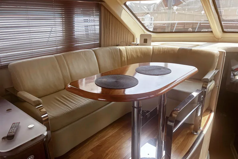 Slide: The Image of Luxurious interior of 2006 Sea Ray 52 Sedan Bridge yacht with leather seating and wooden table. - 27