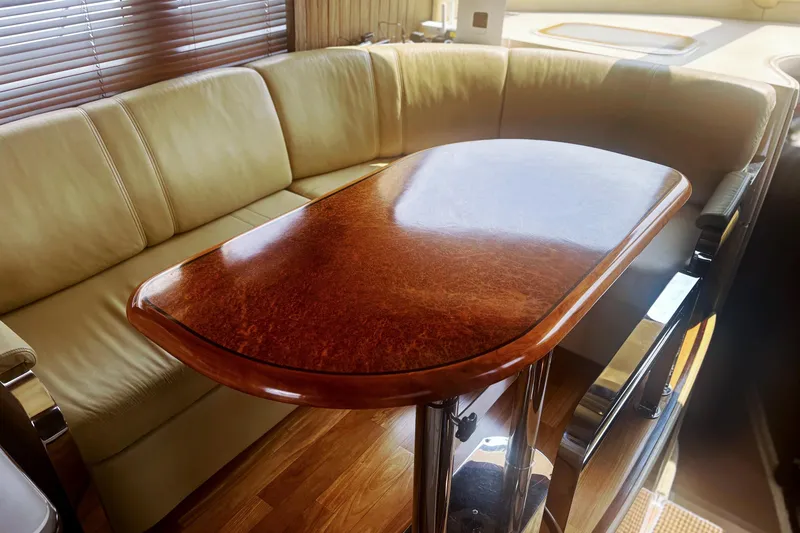 Slide: The Image of Luxurious interior of 2006 Sea Ray 52 Sedan Bridge with elegant wood table and leather seating. - 28