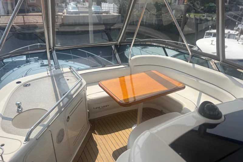 Slide: The Image of 2006 Sea Ray 52 Sedan Bridge interior with seating and table, featuring a compact sink. - 8
