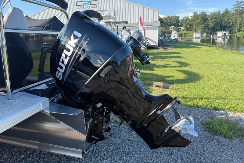 Slide: The Image of 2026 Avalon Venture 85 Rear Fish with Suzuki outboard motor by a marina. - 12