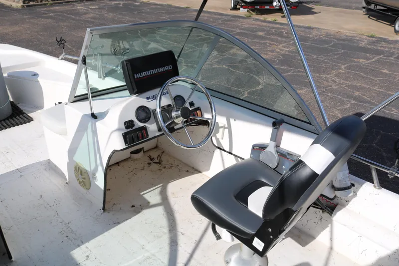 Slide: The Image of 2008 Blue Wave 220 Deluxe Pro boat cockpit with steering wheel and Humminbird display. - 14