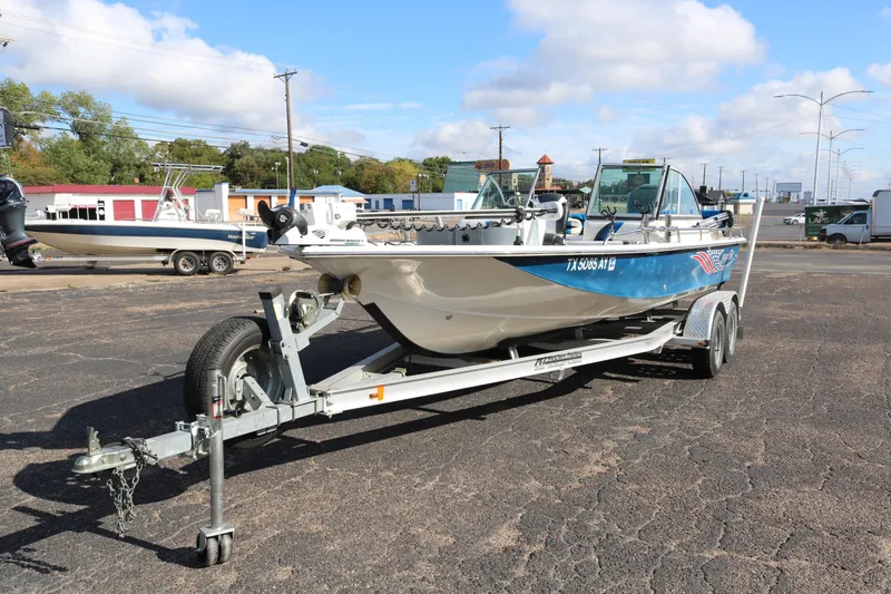 Slide: The Image of 2008 Blue Wave 220 Deluxe Pro boat on trailer in parking lot under blue sky. - 2