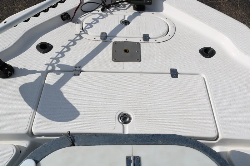 Slide: The Image of 2008 Blue Wave 220 Deluxe Pro boat deck with storage compartments and fishing rod holders. - 20