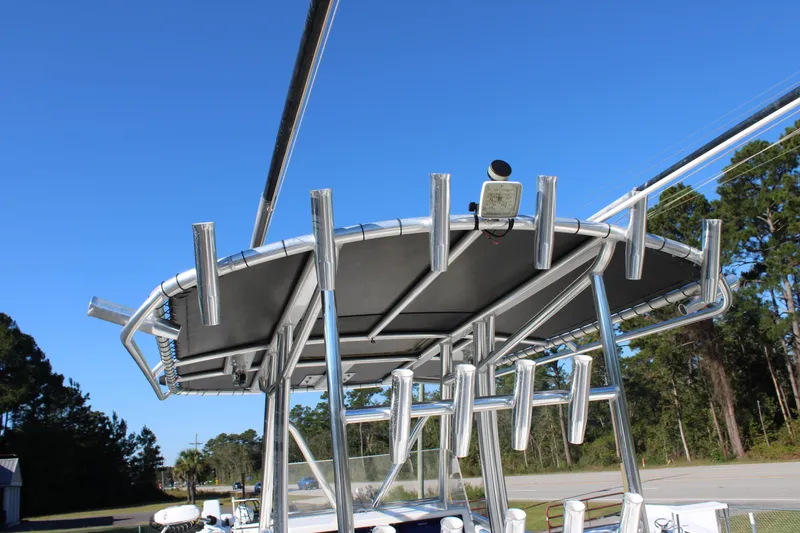 Slide: The Image of 2020 AMERICAT 27cc boat with rod holders and canopy against clear blue sky. - 23