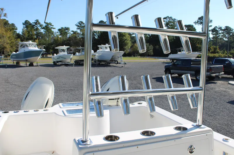 Slide: The Image of 2020 AMERICAT 27cc boat with rod holders, parked in a marina with other boats. - 26