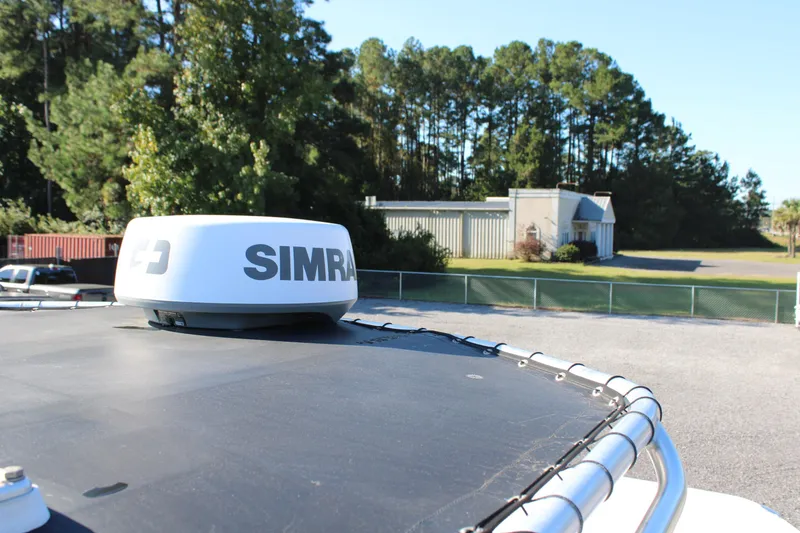 Slide: The Image of Rooftop view of 2020 AMERICAT 27cc with Simrad radar, surrounded by trees and buildings. - 27