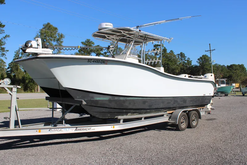 Slide: The Image of 2020 AMERICAT 27cc boat on trailer, parked outdoors on gravel. - 3