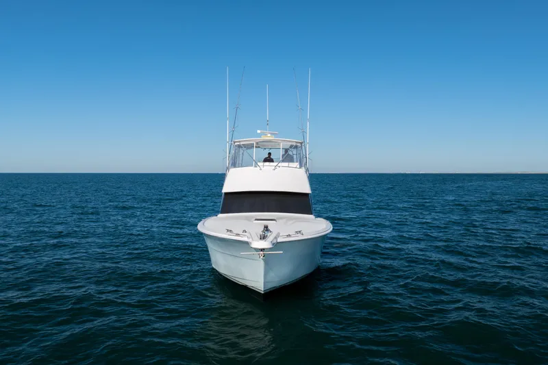 Slide: The Image of Hatteras 50 Convertible yacht from 2000 on open sea under clear blue sky. - 2